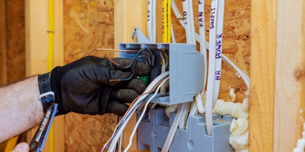 Electrician installing electrical outlet in a new home.