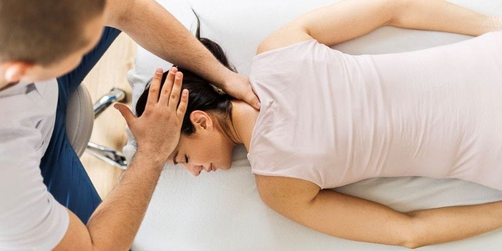 Woman getting an adjustment from a chiropractor.