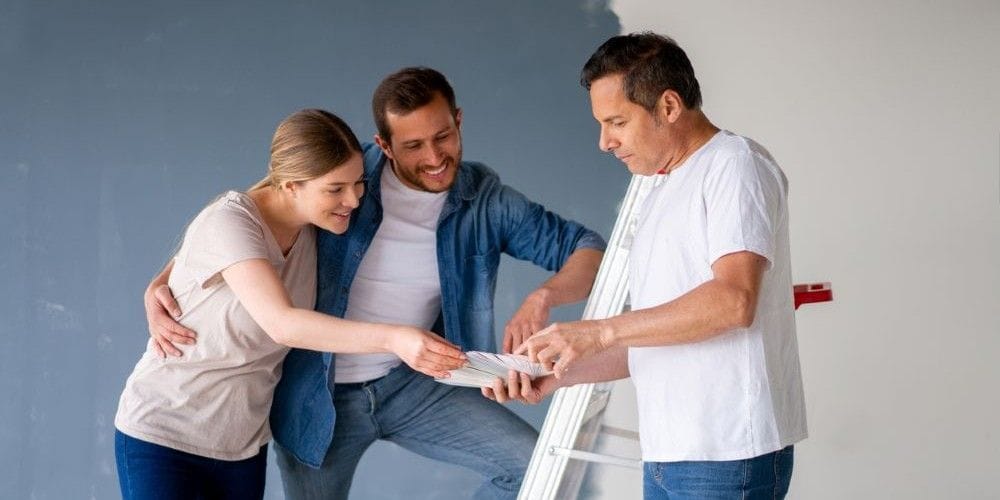 Painter working with customers to decide on the color the paint the inside of the house.