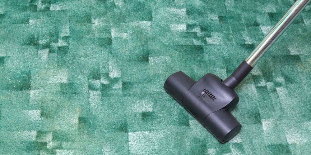 Vacuum cleaning the carpet.